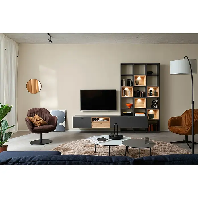 SCHÖNER WOHNEN-Farbe Wandfarbe DesignfarbeWohliges Naturbeige, Matt, 100 ml, Konservierungsmittelfrei - Modernes Wohnzimmer mit grauem TV-Möbel, Regal mit integrierter Beleuchtung, braunen Sesseln, Couchtisch und Teppich für ein gemütliches Ambiente.
