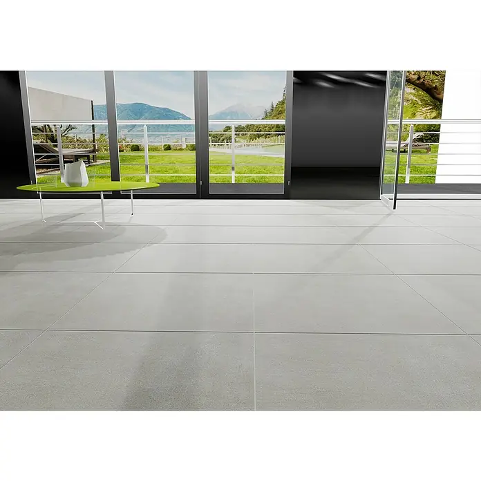 Marazzi Feinsteinzeugfliese Boston - 60 x 60 cm, Grau, Matt - Großformatige, graue Bodenfliesen schaffen eine moderne Ästhetik in diesem hellen Raum mit Blick auf die Natur. Die glatte Oberfläche betont die klaren Linien.