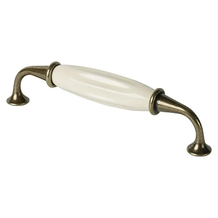 Nesu Tirador para muebles Bronce Viejo - Largo: 128 mm, Porcelana, Beige - Primer plano de un armario de barril crema o tirador frontal de cajón con detalles en bronce sobre un fondo negro.