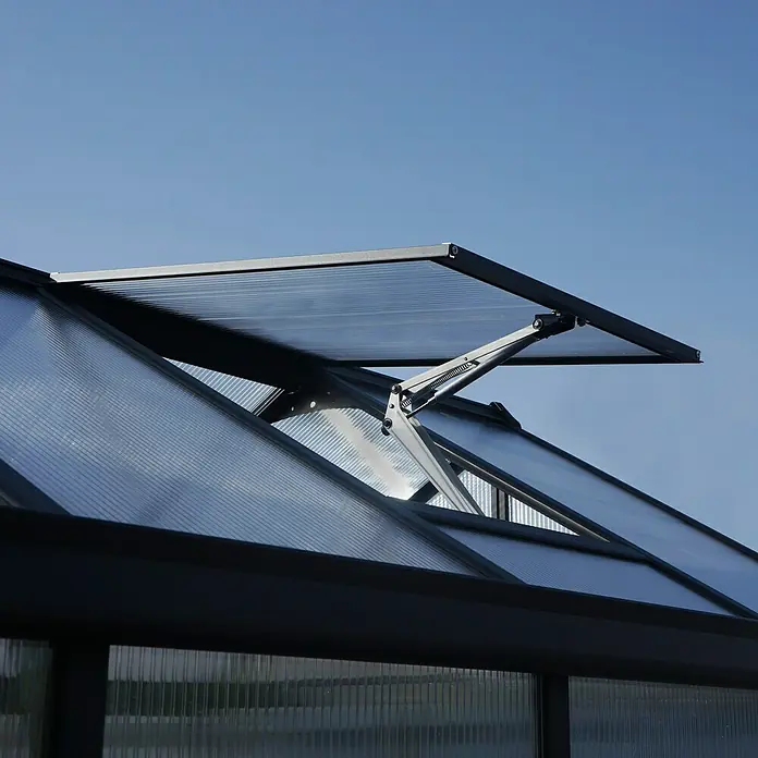 Palram – Canopia Invernadero Glory - Medidas ext. (An x Pr): 195,5 x 244,5 cm, 10 mm, Antracita - Primer plano de una ventana de invernadero con un mecanismo de apertura automática contra un cielo azul claro.