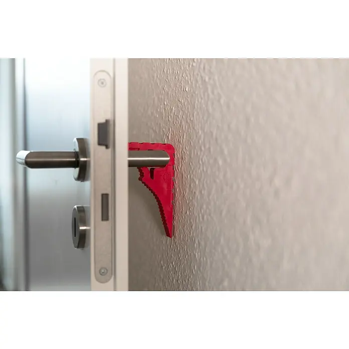 Schellenberg Tür- & Fensterstopper - Pink - Nahaufnahme eines roten Türstoppers, der zwischen Türklinke und Wand platziert ist, um die Tür offen zu halten.