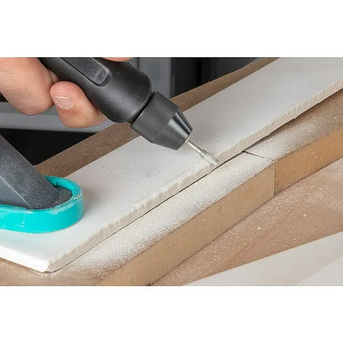 Wolfcraft Fresa de diamante - Diámetro: 4 mm - 5,5 mm, Diámetro vástago: 3 mm, 3 pzs. - Un primer plano muestra una herramienta Dremel que se usa para rectificar una pieza de panel de yeso, lo que garantiza un borde limpio y liso.