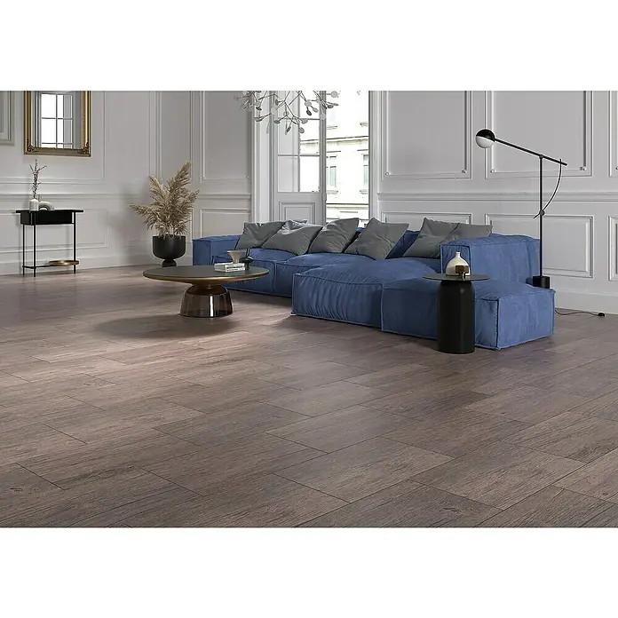 Feinsteinzeugfliese Betulla 2.0 - 30 x 60 cm, Braun, Matt - Wohnzimmer mit blauem Sofa, Couchtisch und Holzboden. Die Holzböden sind das Highlight des Raumes.
