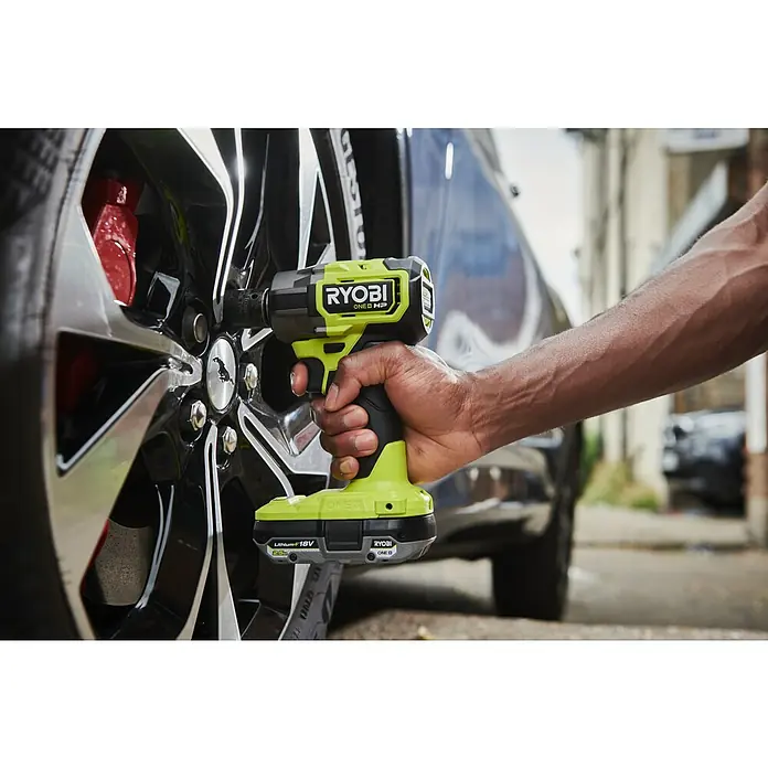 Ryobi ONE+HP Akku-Schlagschrauber RIW18C-0 - 18 V, Ohne Akku, 450 Nm - Nahaufnahme eines Ryobi ONE+ HP Akku-Schlagschraubers beim Radwechsel, der durch sein kompaktes Design überzeugt.