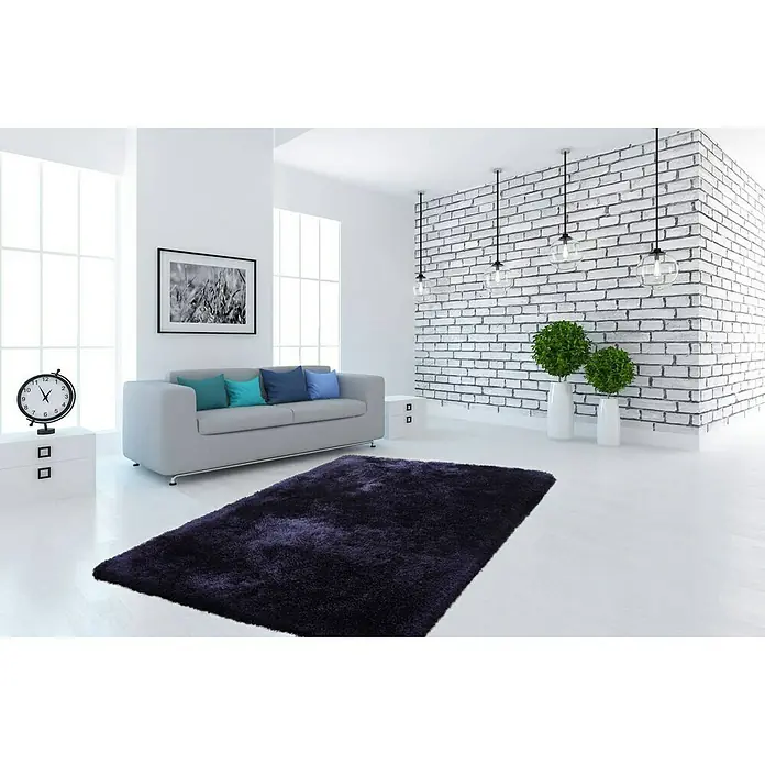 Kayoom Hochflorteppich Cosy - Blau, 290 x 200 cm, 100 % Polyester - Ein modernes Wohnzimmer mit einem grauen Sofa und einem dunkelvioletten, luxuriösen Shaggy-Teppich, der den Raum aufwertet.
