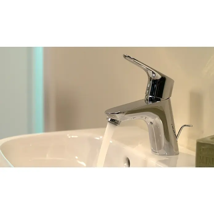 Hansgrohe Waschtischarmatur Focus 70 - Chrom, Glänzend - Glänzender Wasserhahn aus Chrom in einem modernen Badezimmer, Wasser läuft. Der Fokus liegt auf dem eleganten Design des Wasserhahns.