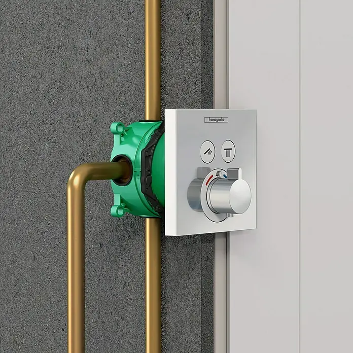 Hansgrohe Unterputzsystem Ibox Universal - 80 x 151 x 122 mm, Grün - Einbauthermostat von Hansgrohe mit einem verchromten Griff und grünen Thermostatkörper mit Rohren.