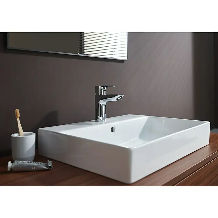 Hansgrohe MySport Waschtischarmatur L - Chrom, Glänzend - Nahaufnahme eines modernen Waschbeckens mit Armatur, Zahnbürste und Zahnpasta im Badezimmer. Elegantes Design für ein stilvolles Badambiente.