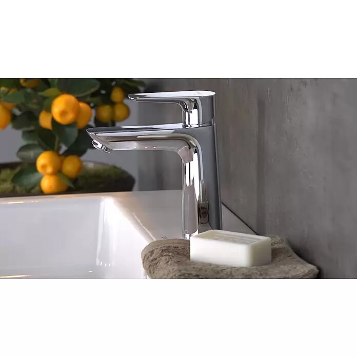 Hansgrohe Talis E Waschtischarmatur 110 - Chrom, Glänzend - Moderner Chrom-Wasserhahn auf einem weißen Waschbecken, mit Seife und Handtuch daneben.