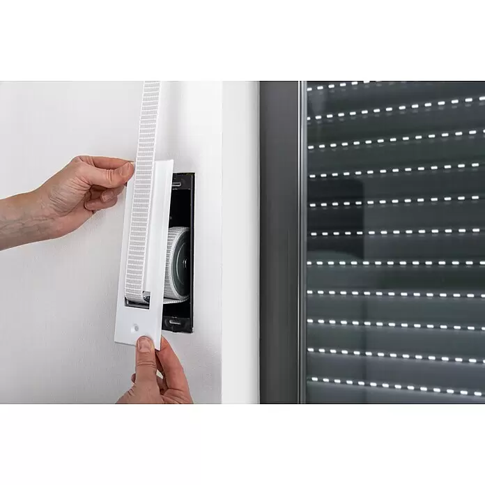 Schellenberg Recogedor de cinta de persiana Maxi - Distancia entre orificios: 160 mm, Anchura de la correa: 23 mm, Máx. Longitud de la cinta: 5,3 m - Recogedor de persiana blanco con correa blanca y gris siendo instalado.