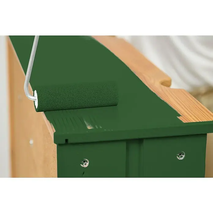 swingcolor Buntlack Acryl - Laubgrün, Glänzend, 125 ml, Wasserbasiert - Farbe auftragen mit einer Farbwalze. Die Farbe ist ein dunkles Grün, das einen Kontrast zu dem hellen Holz bietet, das gerade bemalt wird.