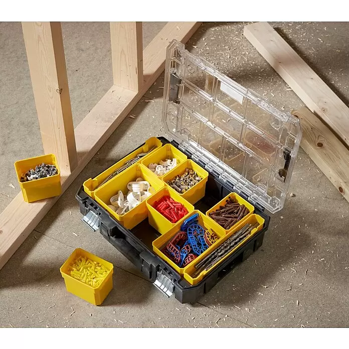 Stanley FatMax Kleinteilekoffer PRO-STACK™ - B x T x H: 337 x 440 x 119 mm, Anzahl Fächer: 10 Stk. - Offene schwarze Organizer-Box mit gelben Fächern voller Hardware auf Betonboden und Holzrahmen.