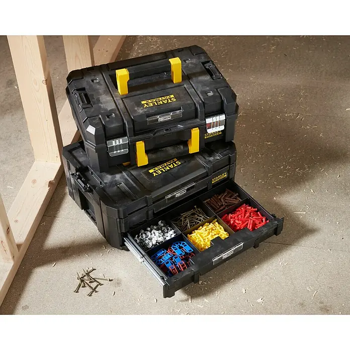 Stanley TSTAK Caja para herramientas grande con 2 cajones - 33,17 x 44 x 32,16 cm - Una pila de cajas de herramientas negras Stanley Fatmax Pro-Stack con detalles amarillos, la caja inferior tiene un cajón lleno de herramientas.