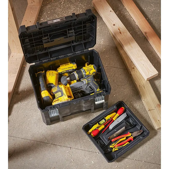 Stanley TSTAK Caja para herramientas grande - 33,2 x 44 x 30,15 cm - Caja de herramientas negra Stanley Fatmax Pro-Stack llena de herramientas amarillas y bandeja de herramientas negra sobre un suelo de madera.
