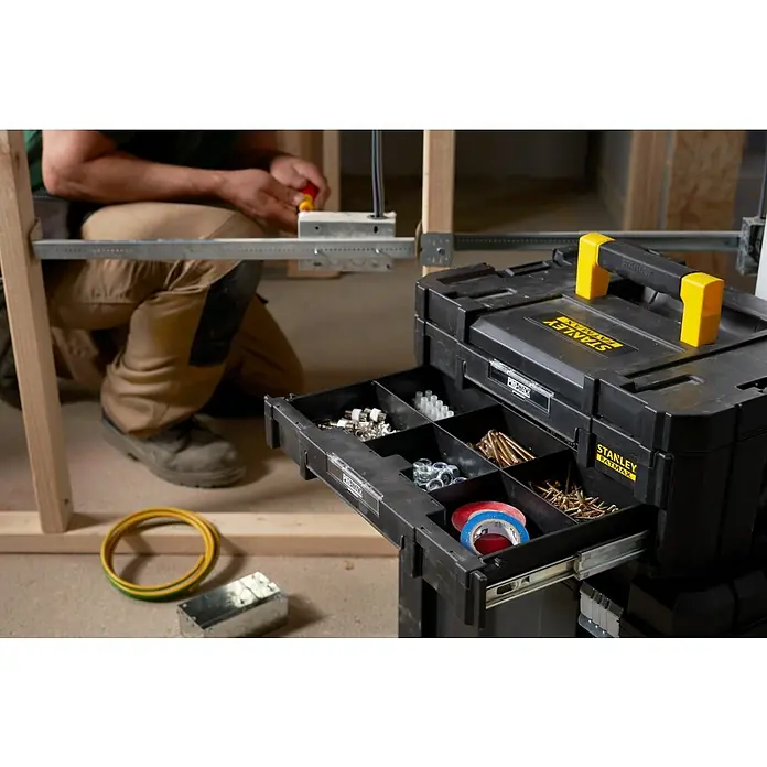 Stanley TSTAK Caja para herramientas con 2 cajones - 31,42 x 44 x 17,6 cm - Una caja de herramientas negra Stanley Fatmax con asas amarillas, cajones abiertos y llenos de herramientas.