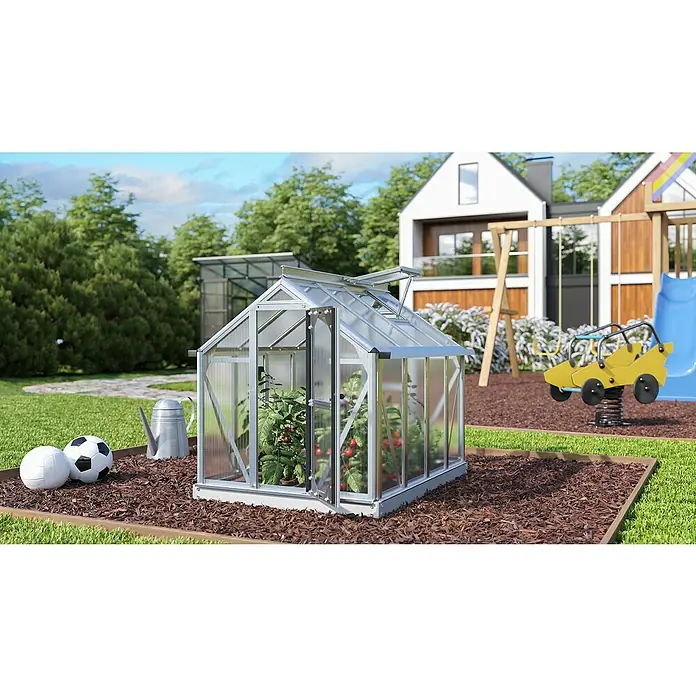 Vitavia Gewächshaus Merlin - Außenmaß inkl. Dachüberstand (B x T): 87,2 x 111,6 cm, Material Seitenwand: Kunststoff, 4 mm, Aluminium - Ein Gewächshaus mit geöffneter Tür, das mit reifen Tomatenpflanzen gefüllt ist, steht im Garten. Bälle und eine Gießkanne stehen davor.