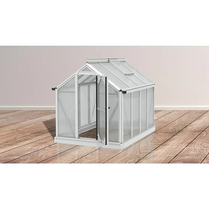 Vitavia Gewächshaus Merlin - Außenmaß inkl. Dachüberstand (B x T): 87,2 x 111,6 cm, Material Seitenwand: Kunststoff, 4 mm, Aluminium - Aufnahme eines kleinen Gewächshauses mit geöffneter Tür, das auf einem Holzboden vor einer schlichten, hellen Wand steht.