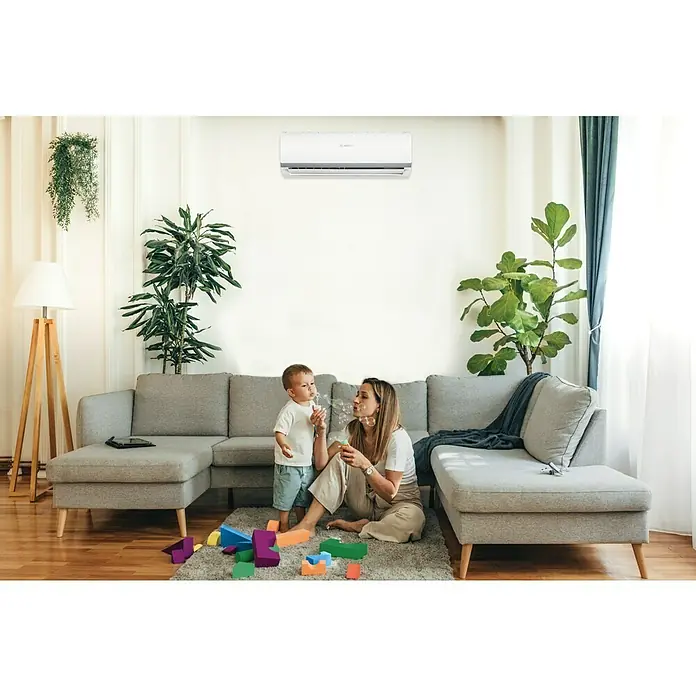 Bosch Aire acondicionado Inverter Climate 2000 - 2.600 W, 3.000 W, 16 m², Blanco - Un aire acondicionado Bosch cuelga sobre una familia haciendo burbujas, asegurando un ambiente confortable en la habitación con diseño moderno.