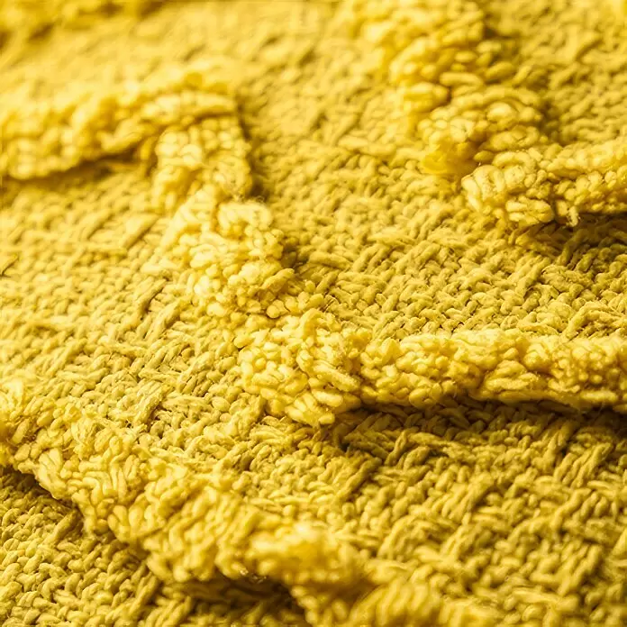 Kissen Ravi Mimosa - Gelb, 45 x 45 cm, 100 % Baumwolle - Nahaufnahme eines weichen, gelben Schlingenstoffs, der seine plüschige Textur zeigt.
