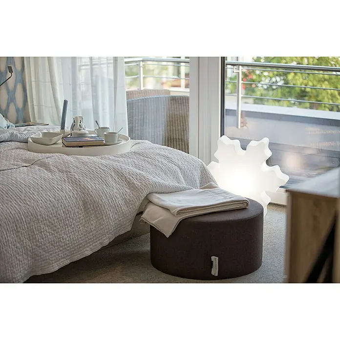 8 Seasons Design Shining LED-Solar-Weihnachtsleuchte Crystal - 2 W, Weiß, Durchmesser: 60 cm - Schlafzimmer Interieur mit einem runden braunen Hocker, darauf eine gefaltete weiße Decke und einer dekorativen Schneeflockenlampe, die ein angenehmes Licht ausstrahlt.