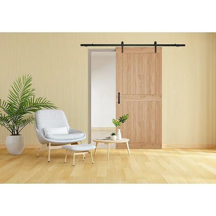 Puerta corredera de madera Harper - An x Al: 85 x 210 cm - Una puerta corredera de madera clara con herrajes negros, parcialmente abierta, que complementa una acogedora zona de estar con una silla y mesa auxiliar.