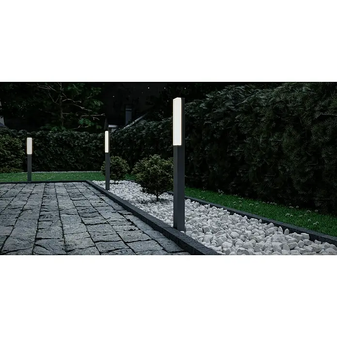 Starlux Laholm Außensockelleuchte - 8 W, Farbe Gehäuse: Dunkelgrau, Warmweiß, 7 x 5,2 x 90 cm, Mit Leuchtmittel - Elegante Gartenbeleuchtung mit modernen Pollerleuchten entlang eines gepflasterten Weges und weißem Kies.