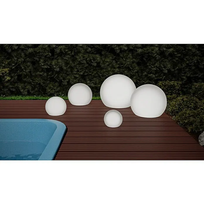 New Garden Solar-Kugelleuchte BulyDurchmesser: 60 cm, IP65 - Eine stimmungsvolle Szene mit runden Gartenleuchten in verschiedenen Größen auf einer Holzterrasse neben einem Pool.