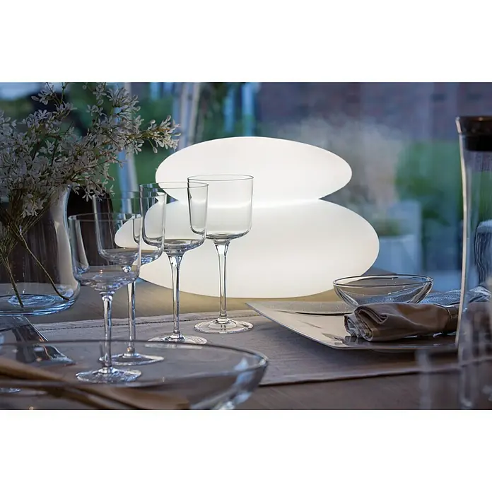 8 Seasons Design Shining LED-Solar-Dekoleuchte Stone - Weiß, L x B x H: 29 x 39 x 22 cm - Stimmungsvolle Tischdekoration mit eleganten Weingläsern und einer modernen, ovalen Lampe, die ein warmes Licht verbreitet.