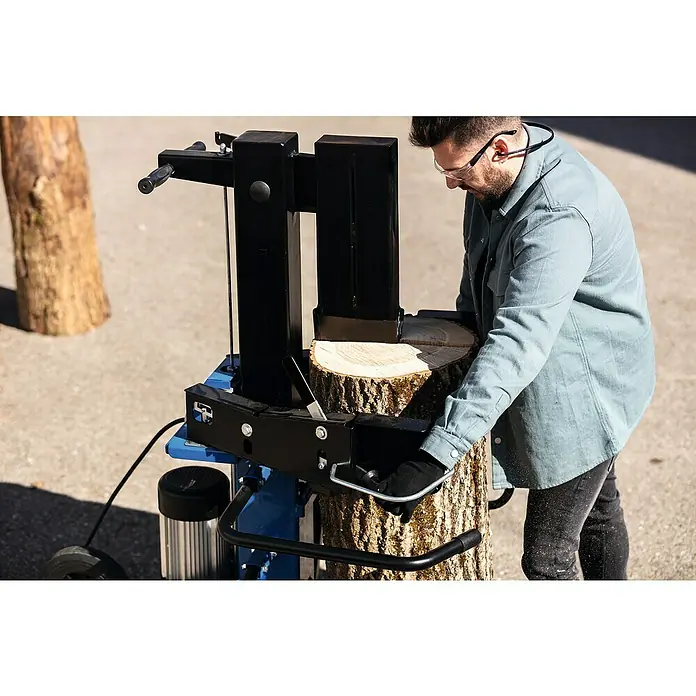 Scheppach Holzspalter Compact 15T - 15 t, Max. Spaltgutlänge: 107 cm - Ein Mann bedient einen Holzspalter, um einen Baumstamm zu spalten. Der Holzspalter ist blau und schwarz, und der Baumstamm ist hellbraun.