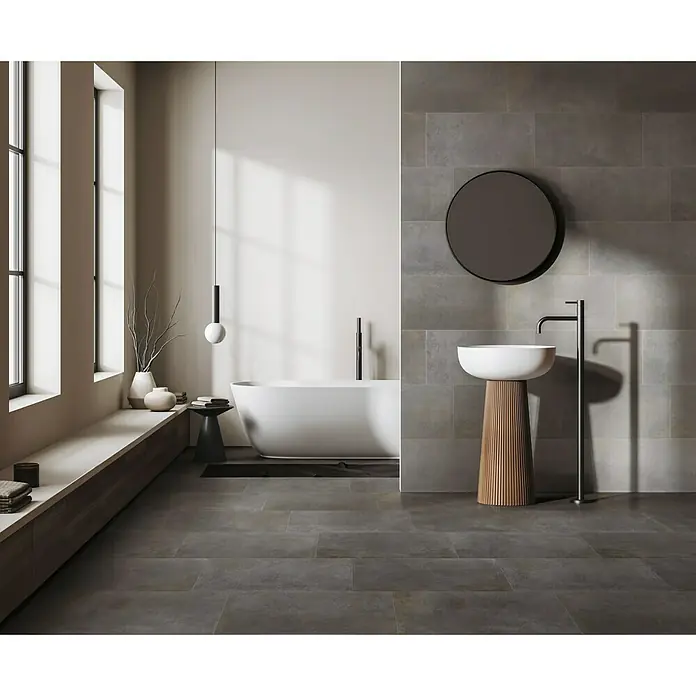 Feinsteinzeugfliese Metallbeton - 30 x 60,4 cm, Hellgrau, Matt - Ein modernes Badezimmer mit dunklen Fliesen, einer freistehenden Badewanne und einem Waschtisch mit rundem Spiegel.