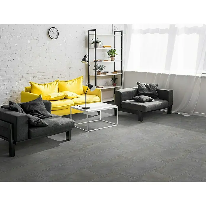 Feinsteinzeugfliese Metallbeton - 30 x 60,4 cm, Hellgrau, Matt - Helle Wohnungseinrichtung mit gelbem Sofa, grauen Sesseln, Bücherregal und weißem Tisch mit Lampe für ein modernes und gemütliches Ambiente.