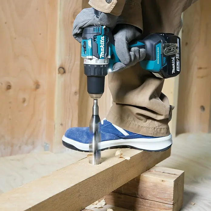 Makita LXT 18V Akku-Bohrschrauber DDF484RTJ - 18 V, 2 Akkus, 5 Ah, 54 Nm - Der Makita Akku-Bohrschrauber beim Bohren eines Lochs in ein Holzbrett. Das Werkzeug ist leistungsstark und effizient.