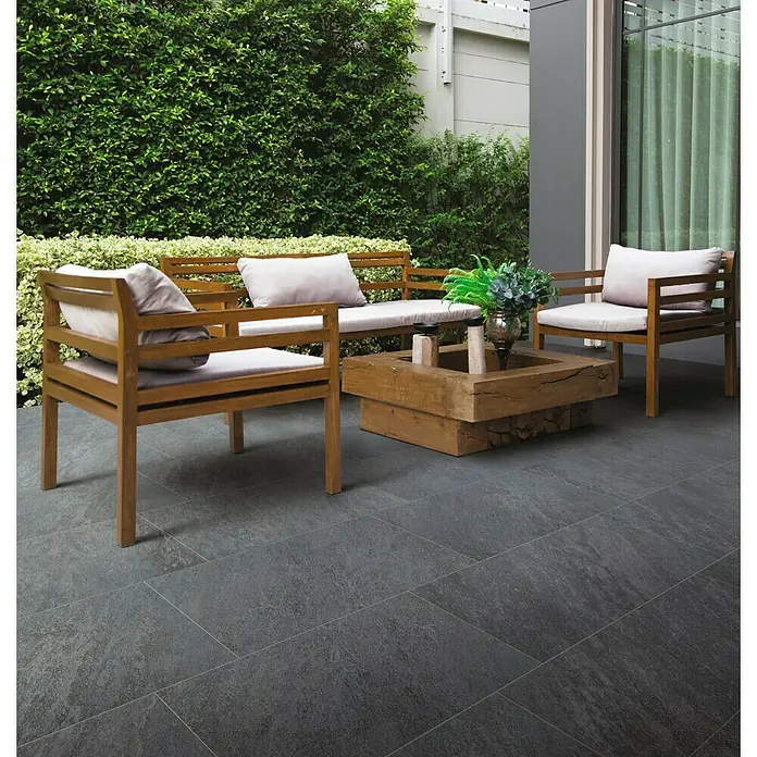 Feinsteinzeugfliese Skiffer - 30 x 60 cm, Anthrazit, Matt - Elegante Außenterrasse mit grauen Steinzeugfliesen, die einen modernen und stilvollen Look verleihen. Passende Gartenmöbel runden das Gesamtbild ab.