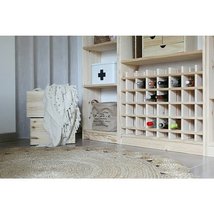 Astigarraga Estantería para botellas Rioja - L x An x Al: 54 x 22 x 75 cm - Botellero de madera clara con botellas llenas, al lado de cajas y alfombra.