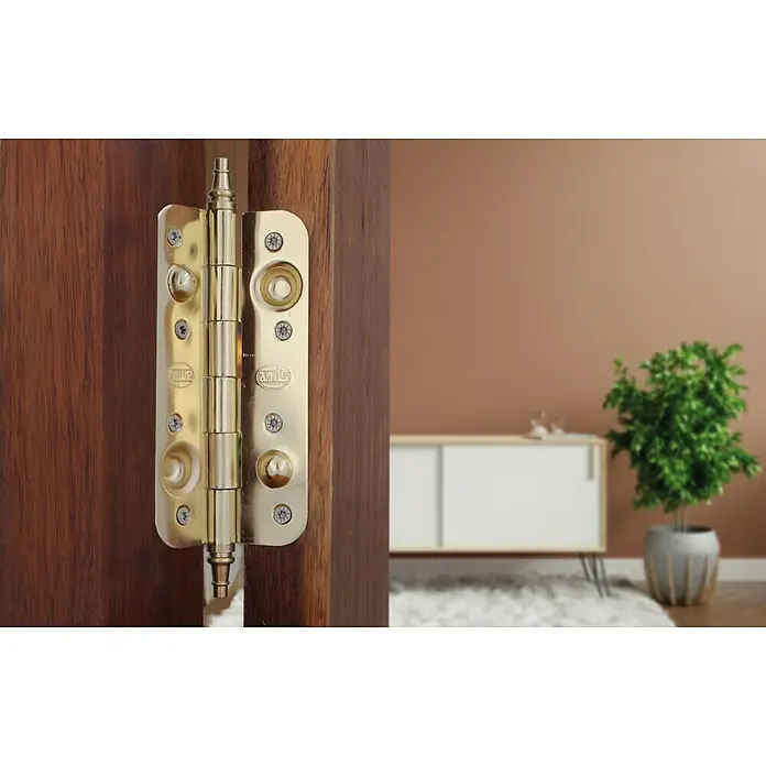 Bisagra 566 - 150 x 82 x 14 mm, Latón, 1 ud. - Vista detallada de una bisagra de puerta dorada brillante en una puerta de madera, destacando su alta calidad artesanal.