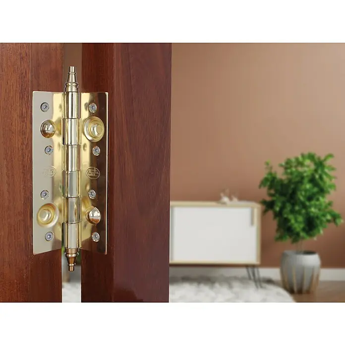Bisagra mod. 561 - L x An: 150 x 80 mm, Bronce - Primer plano de una bisagra de puerta dorada en una puerta de madera, destacando los intrincados detalles y la artesanía de alta calidad.