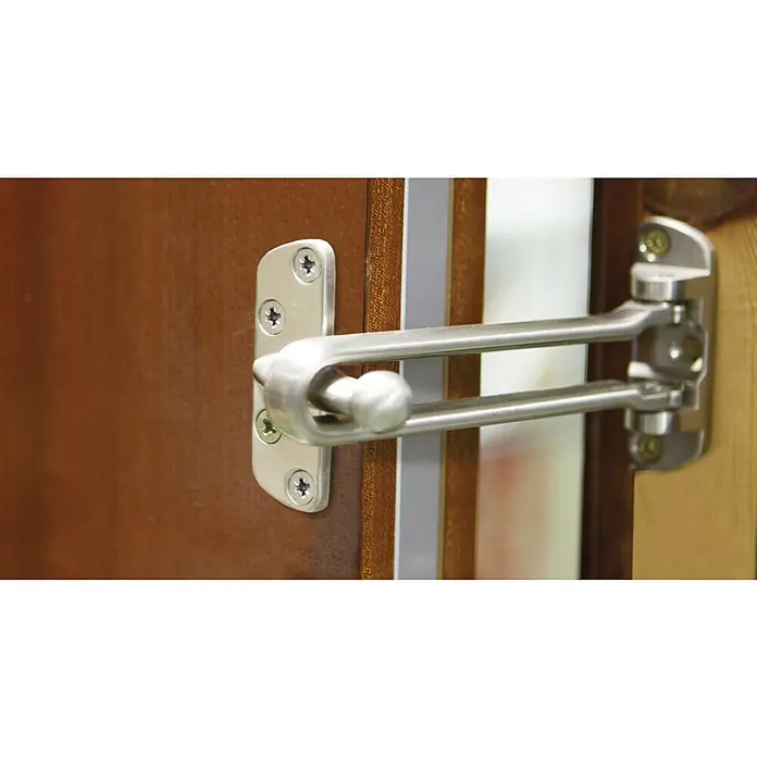 Cadena de puerta maciza - Plateado - Barra de seguridad metálica para puerta para mayor seguridad. La barra está sujeta a una puerta de madera.