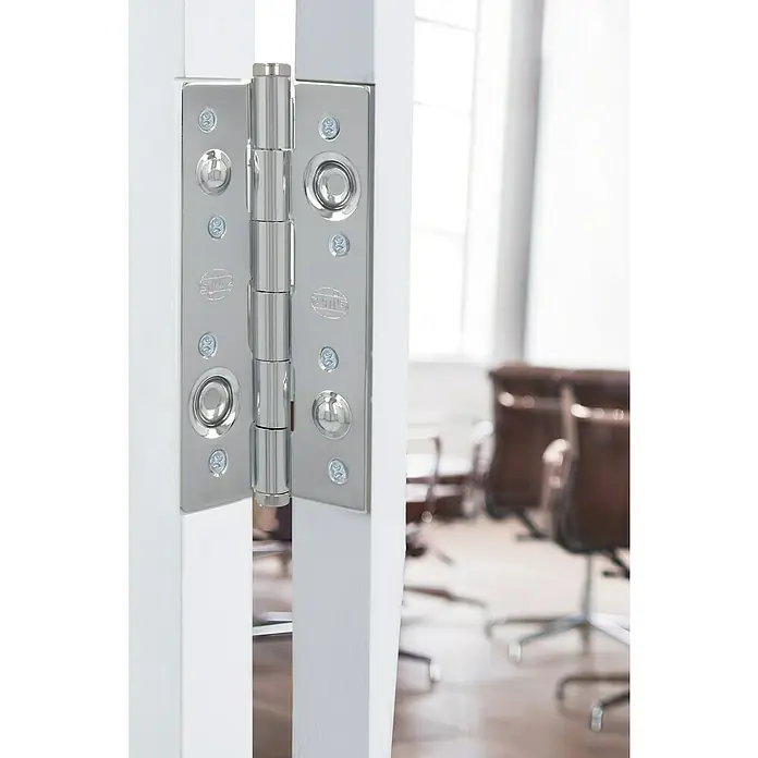Bisagra mod. 565 - 150 x 80 x 3 mm, Cromo, 1 ud. - Primer plano de una bisagra de puerta de metal pulido de alta calidad en una puerta blanca, que combina funcionalidad con diseño moderno.