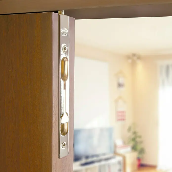 Pestillo con bloqueo de embutir - 200 x 17 mm - Primer plano de un cerrojo metálico SPKW en una puerta de madera, ideal para la privacidad y la seguridad en interiores.