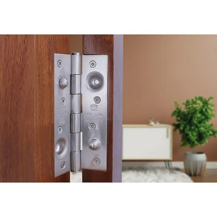 Bisagra mod. 565 - 150 x 80 x 3 mm, Acero inoxidable - Primer plano de una bisagra de puerta de acero inoxidable en una puerta de madera que muestra los herrajes y el diseño interior.