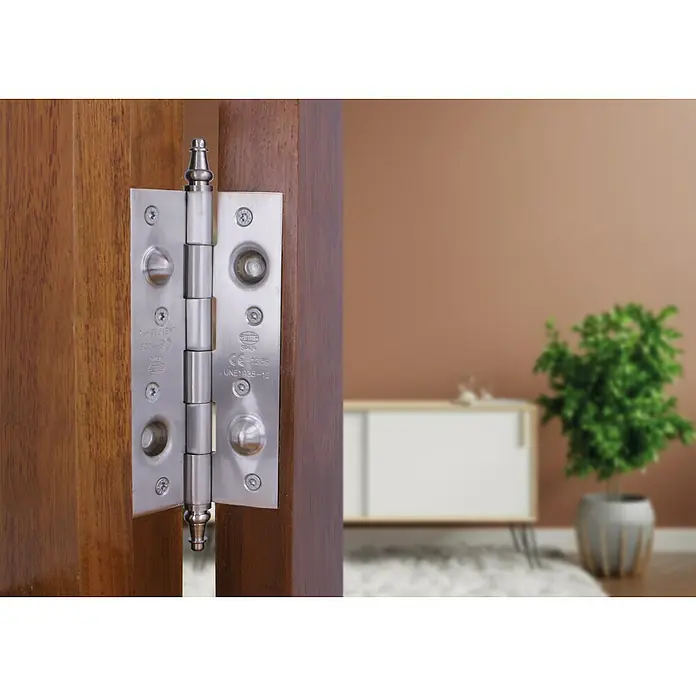 Bisagra mod. 561 - L x An: 150 x 80 mm, Cromo - Primer plano de una bisagra de puerta AMIG de acero inoxidable de alta calidad montada en una puerta de madera, conocida por su durabilidad y diseño elegante.