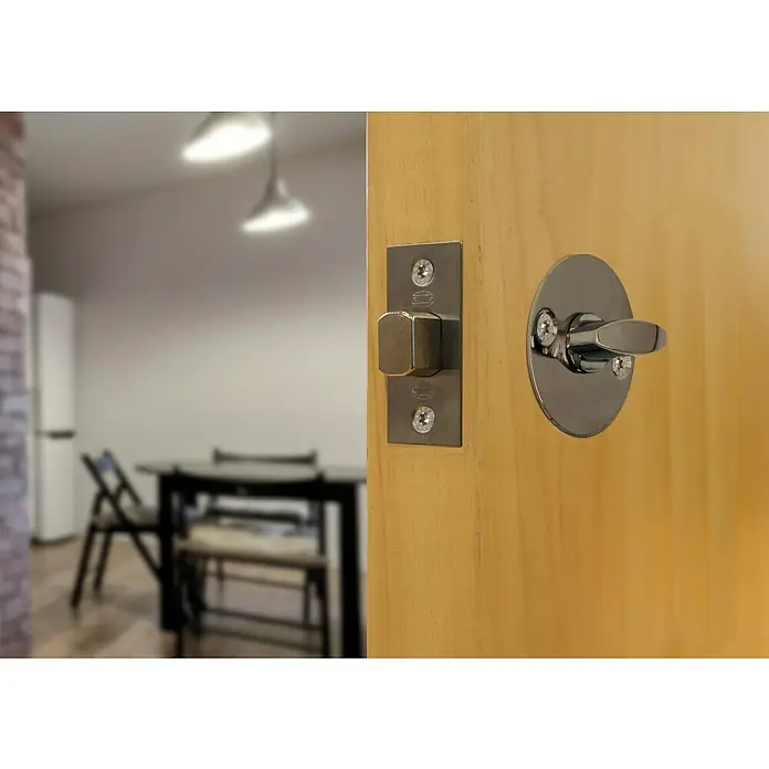 Picaporte 126 - Apto para: Puertas de madera, Niquelado - Primer plano de una cerradura de puerta con acabado plateado montada en una puerta de madera clara. Se trata de una cerradura de diseño moderno.