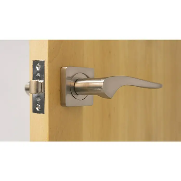 Resbalón 12-45 cuadrado níquel - Apto para: Puertas de madera, Sin cerradura - Primer plano de una manija de puerta moderna de níquel cepillado en una puerta de madera clara.
