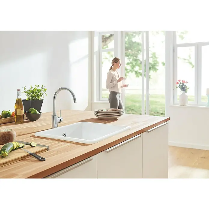 Grohe Concetto Spültischarmatur - Edelstahl, Schwenkbar - Eine moderne Küche mit einer Spüle aus Keramik und einer stilvollen Armatur, die Funktionalität und Design vereint.