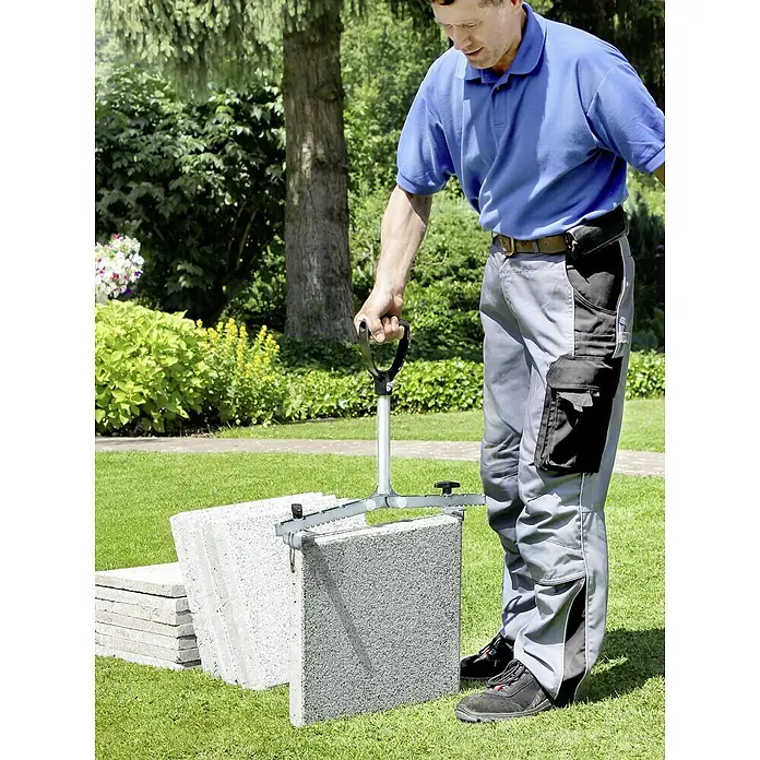 Langfit Plattenheber MS-PH2062L - Geeignet für: Terrassenplatten, Plattengröße: 30 - 62 cm - Ein Mann benutzt einen Pflastersteinheber, um Pflastersteine zu bewegen. Das Werkzeug erleichtert das Anheben und Transportieren schwerer Lasten im Garten.