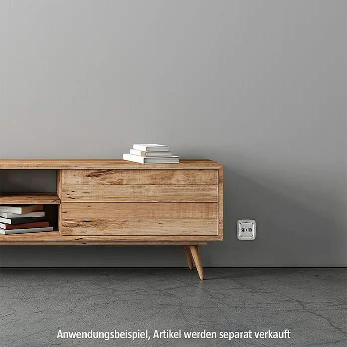 Busch-Jaeger Reflex SI Abdeckrahmen 2511-214 - Alpinweiß, 1-fach, Kunststoff - Wohnzimmer-Szene mit einem hölzernen Sideboard, das Bücher präsentiert. Eine Steckdose ist an der grauen Wand angebracht.