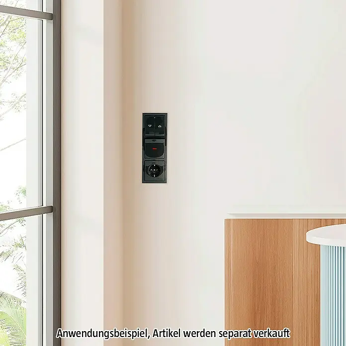 Busch-Jaeger Future Linear Abdeckrahmen 1723-181K - Anthrazit, 3-fach, Kunststoff - Einbau-Schalter und Steckdose in Schwarz an einer weißen Wand, Beispiel für ein modernes Innendesign.