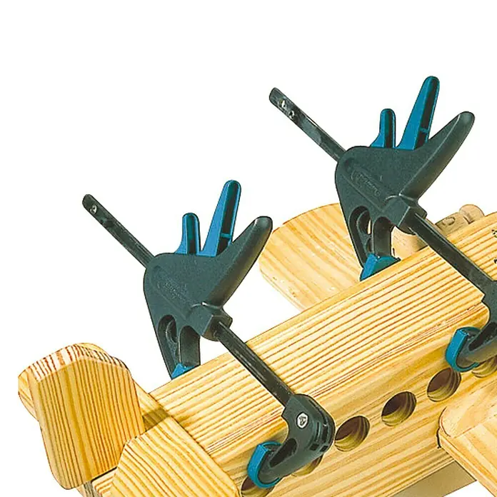 Wolfcraft Einhandzwinge EHZ - Spannweite: 110 mm, Spannkraft: 295 N, Ausladung: 38 mm - Bild zeigt zwei blaue Wolfcraft Einhandzwingen, die ein Holzbauteil fixieren, ideal für Holzbearbeitungsprojekte und Heimwerker.