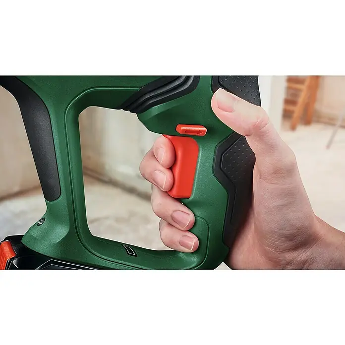 Bosch Professional AMPShare 18V Akku-Kombihammer UniversalHammer 18V - 18 V, 1 Akku, 4 Ah, 2 J - Nahaufnahme eines Mannes, der einen grünen Bosch-Tacker mit rotem Auslöser bedient, der seine Hand zeigt, während er das Werkzeug benutzt.