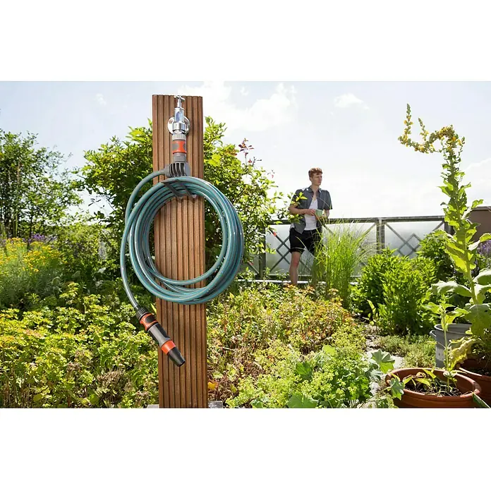 Kit de manguera en espiral City Gardening - Largo: 7,5 m - Escena de jardín con un carrete de manguera. Práctico almacenamiento de mangueras al aire libre, bien enrollado y listo para usar.